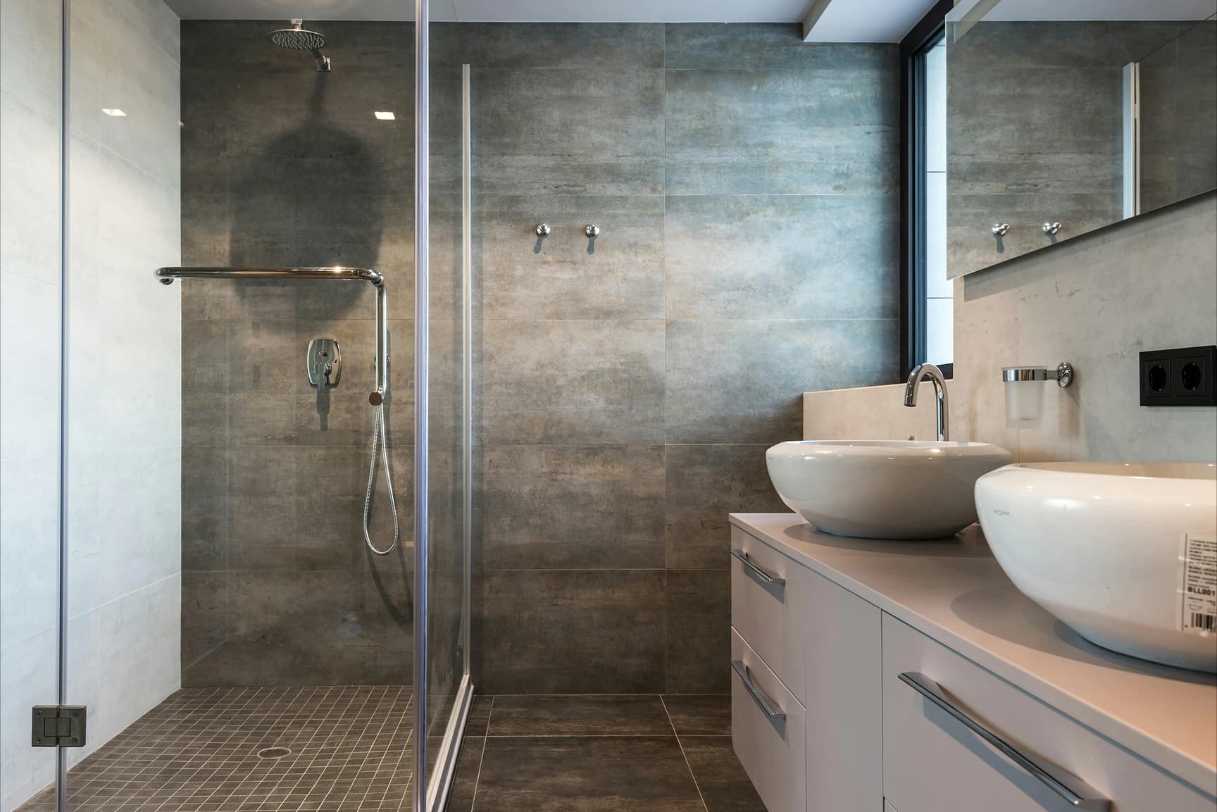 Modern bathroom interior with vessel sinks and stone walls